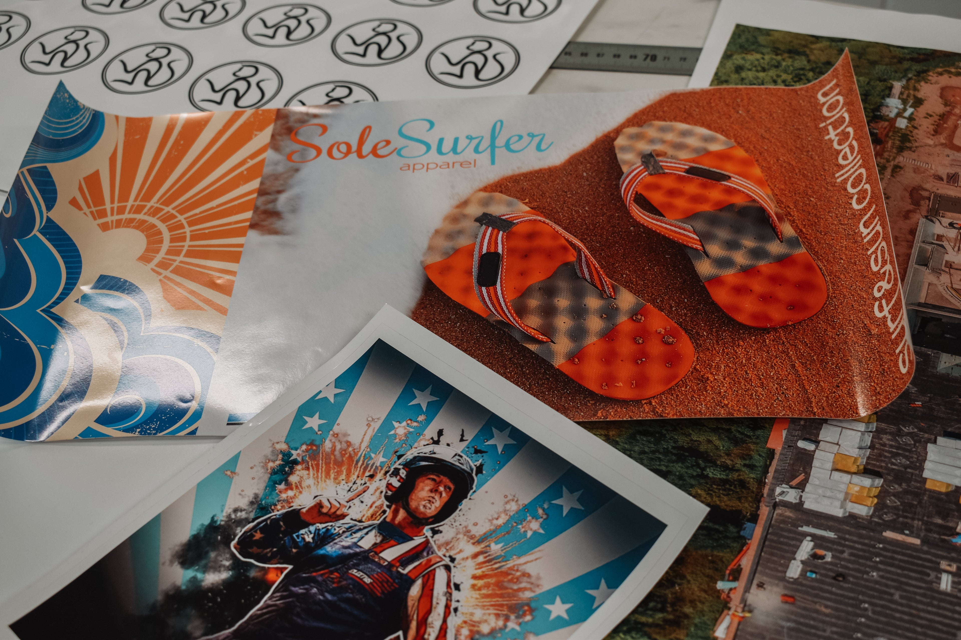 Collection of vinyl prints with various designs, including promotion for a pair of sandals, construction sites, company logos, and a fun custom athlete print.